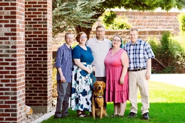 The family behind Royal Windows and Gutters standing together outside with their dog