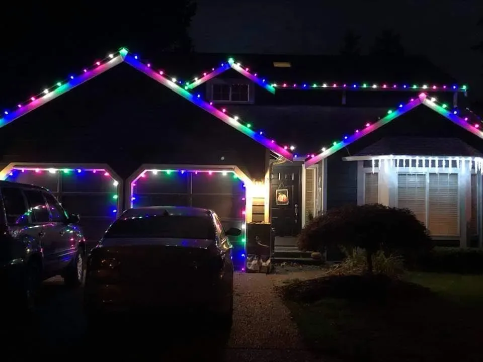 Home lit with multicolor holiday lights across the front rooflines